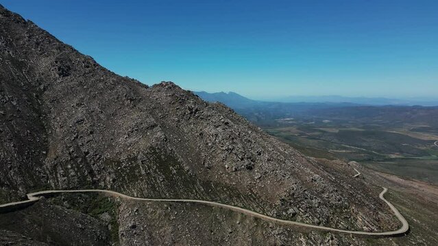 Aerial view - drone flight towards a barren mountain range, Swartberg Pass, South Africa - serpentines can be seen. cinematic shot, epic shot