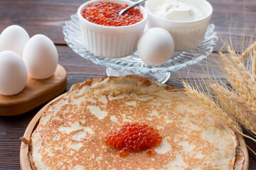 Maslenitsa holiday, pancakes with red caviar and sour cream on the table. The Russian tradition
