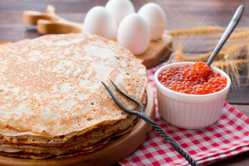 Maslenitsa holiday, pancakes with red caviar and sour cream on the table. The Russian tradition