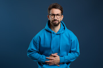 Stomach Pain. Sick young man suffering from acute abdominal ache