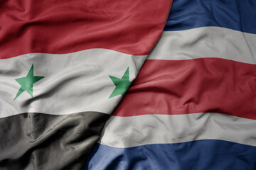 big waving national colorful flag of costa rica and national flag of syria .