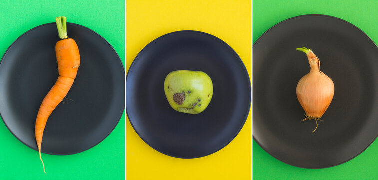 Collage of ugly fruit and vegetable on the black plate. Top view. Close-up.