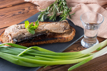 a sandwich with sprats. Fried black bread with smoked fish in oil