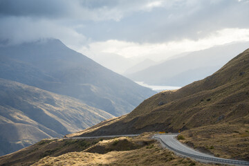 Curvy road leading through mountains pass in alpine environment, New Zealand