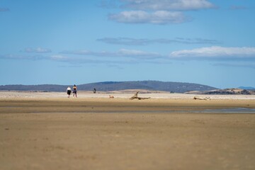 Fototapeta na wymiar family walking on a beach in tasmania australia