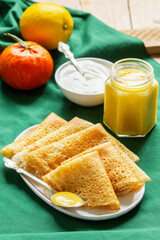 Pancakes served with fruit curd and sour cream, a traditional meal for Maslenitsa and Carnival. - 755906776