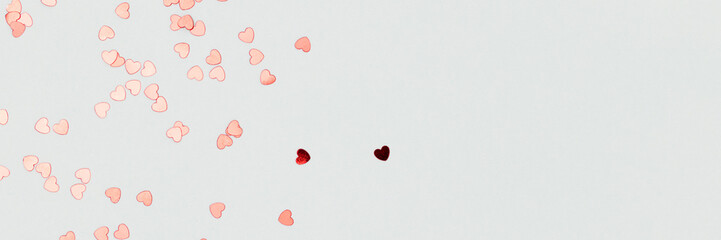 Banner with red confetti in a heart shape on a blue background. Place for text.