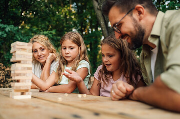 A family spending time in nature and playing jenga game.