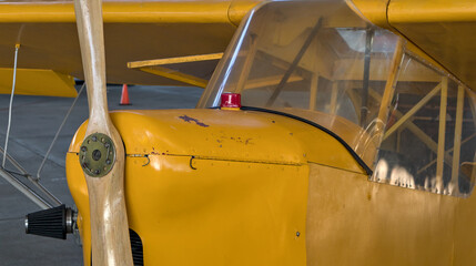 old antique yellow airplane with wooden propeller (close up of cockpit) retro aviation plane detail