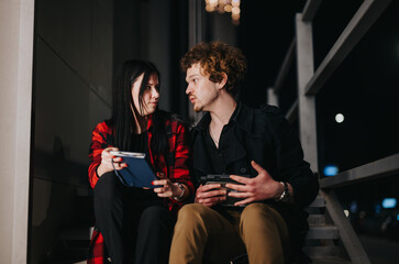 Business associates engaged in a strategic discussion at night, illuminated by ambient lights outdoors.