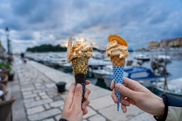 couple eating ice cream in Rovinj harbor with sunlight