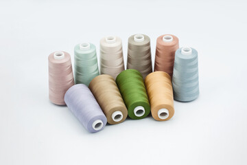 Thread spools background. Various colors sewing kit. Collection of threads. Pale pastel colors. Sew...