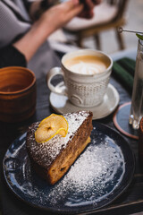 A piece of homemade cake and coffee. Breakfast in a cafe on the street.