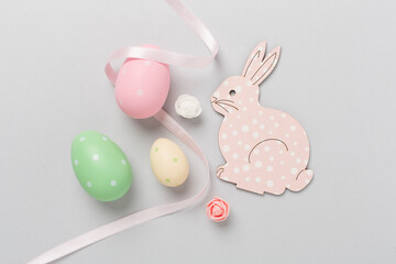 Easter bunny with eggs on color background, top view