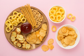 Different tasty snacks with sauce on color background, top view