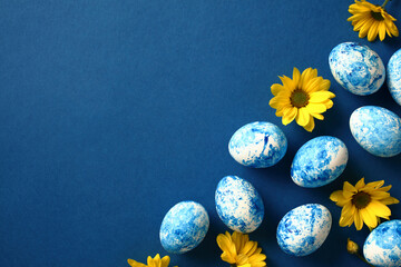 Blue and white Easter eggs with yellow flowers on dark blue background. Easter card template.