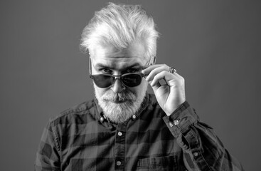 Man with beard and glasses feeling confident. Bearded man with fashion sunglasses. Studio shot of...