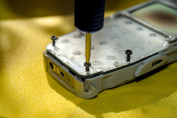 Technician disassembling components of broken phone for repair