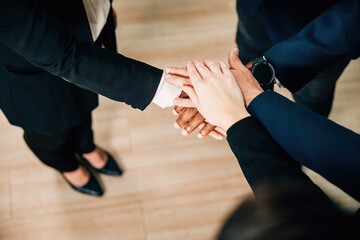 Diverse colleagues hold hands in a circle in a modern office, celebrating care, equality, and community. conveys the essence of cooperation, communication, and the cheerful spirit of achievement.
