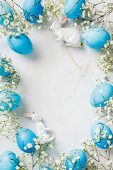 Blue and white Easter scene with two white rabbits and blue eggs. Flat lay, top view