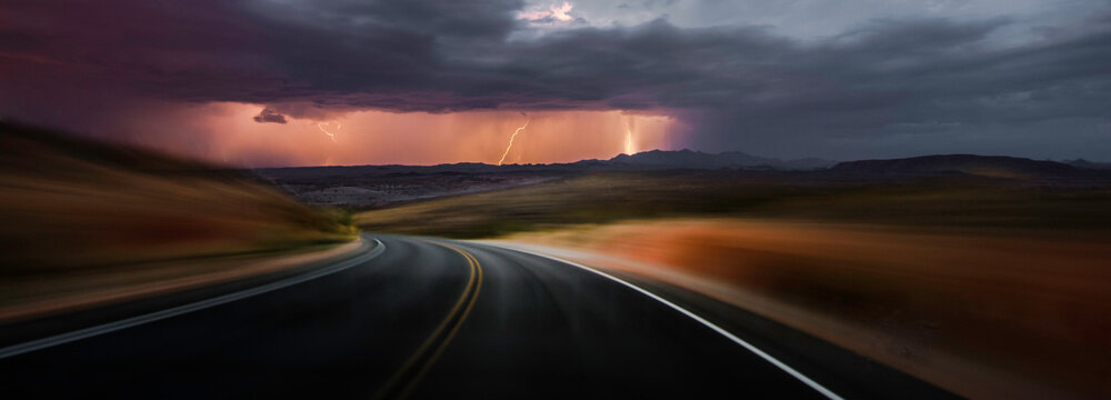 Desert Drive: 4K Ultra HD Image of Driving on a Desert Road with Thunderstorm Ahead