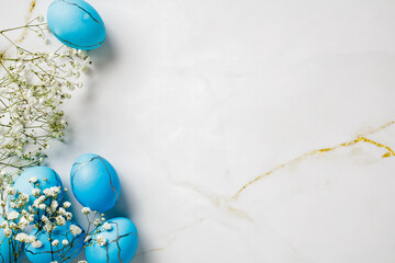 White background with blue eggs and white flowers. Happy Easter concept.