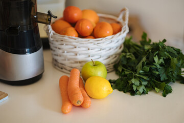Different fruits and vegetables on table. Citrus fruits, lemon, tangerine, orange. Apple, carrots, celery, parsley. Juicer