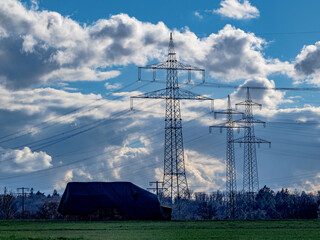 Hochspannungsmasten und Wolkenhimmel