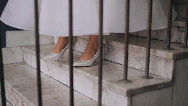 The legs of a girl in shoes who is coming down the stairs. Shooting in slow motion