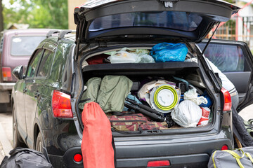 The trunk of a car loaded with camping equipment