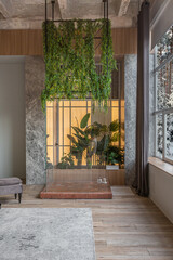 A jungle-styled glass separate shower in greenery in a huge modern spacious apartment with high loft-style ceilings, wooden trim and gray walls
