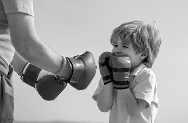 Boxer grandfather and child with blue boxing glove on blue sky background - isolated. Grandfather and grandson doing boxing training in morning. - obrazy, fototapety, plakaty