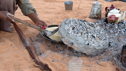 Bread cooking on a camp fire during a camel trek in the Sahara Desert, outside of Douz, Tunisia