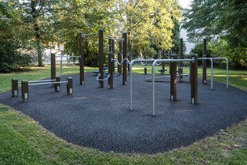 A sporty public playground featuring a horizontal slide, monkey bars, balancer, and modern climbing...