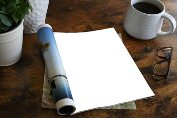 An open magazine laying on a table or desk with a white blank page for mock up.