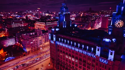 Poster Aerial night view of a vibrant cityscape with illuminated buildings and streets in Liverpool, UK. © Vas