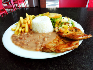 Traditional Brazilian meal known as  prato feito on the restaurant table .