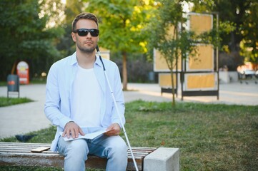 Blinded man reading by touching braille book