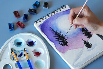 Christmas watercolor. Watercolor winter painting. Top view watercolor painting with a set of brushes, paints and palette 
