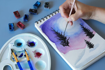Christmas watercolor. Watercolor winter painting. Top view watercolor painting with a set of brushes, paints and palette 