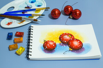 watercolor painting of red balls. Winter watercolor painting with a set of watercolor paints and paintbrushes. Top view