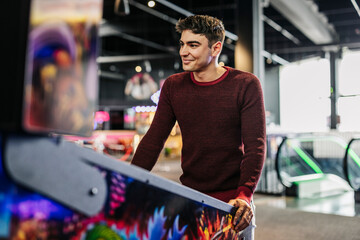 Young Man Strategizing at an Arcade Game