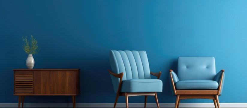 Home decor concept with blueprint, a blue armchair and wooden table against a blue wall, with hardwood flooring.