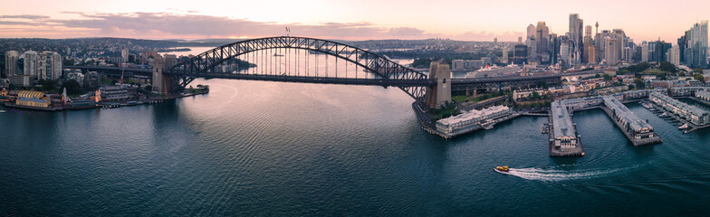Panoramic aerial view of Sydney Harbour Bridge, Sydney Harbour and Sydney City, NSW Australia during an early morning sunrise in March 2024
