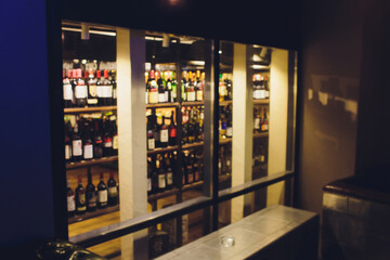 Blurred photo of wine bottle shelf in supermarket.