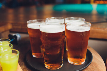 Waiter serving glasses of cold beer on the tray.