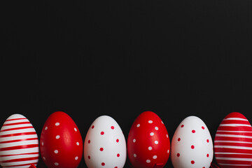 Red and white easter eggs on a black background. Space for text. 