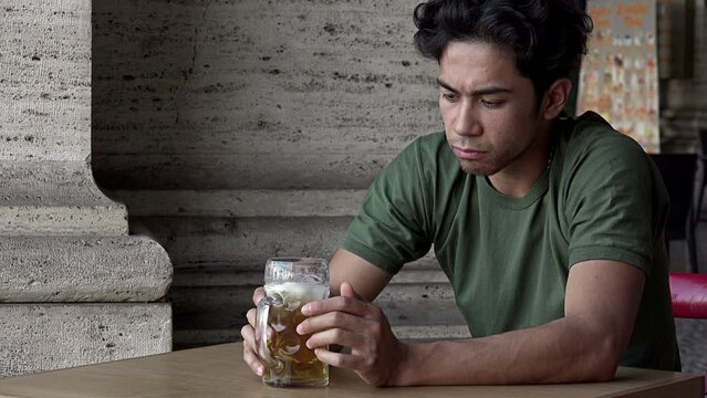 sad young man drinking beer alone and sad: pensive depressed man 
