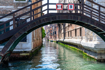 Traditional Venetian Bridge over Serene Canal in Italy