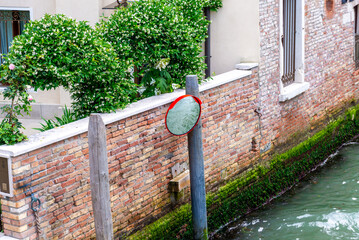 Lush Greenery Along a Venetian Canal with Mooring Post